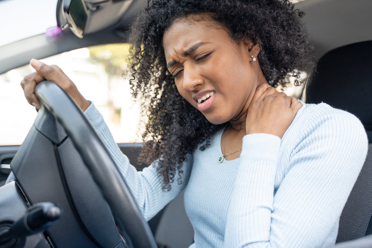 Woman holding her neck in pain after car accident
