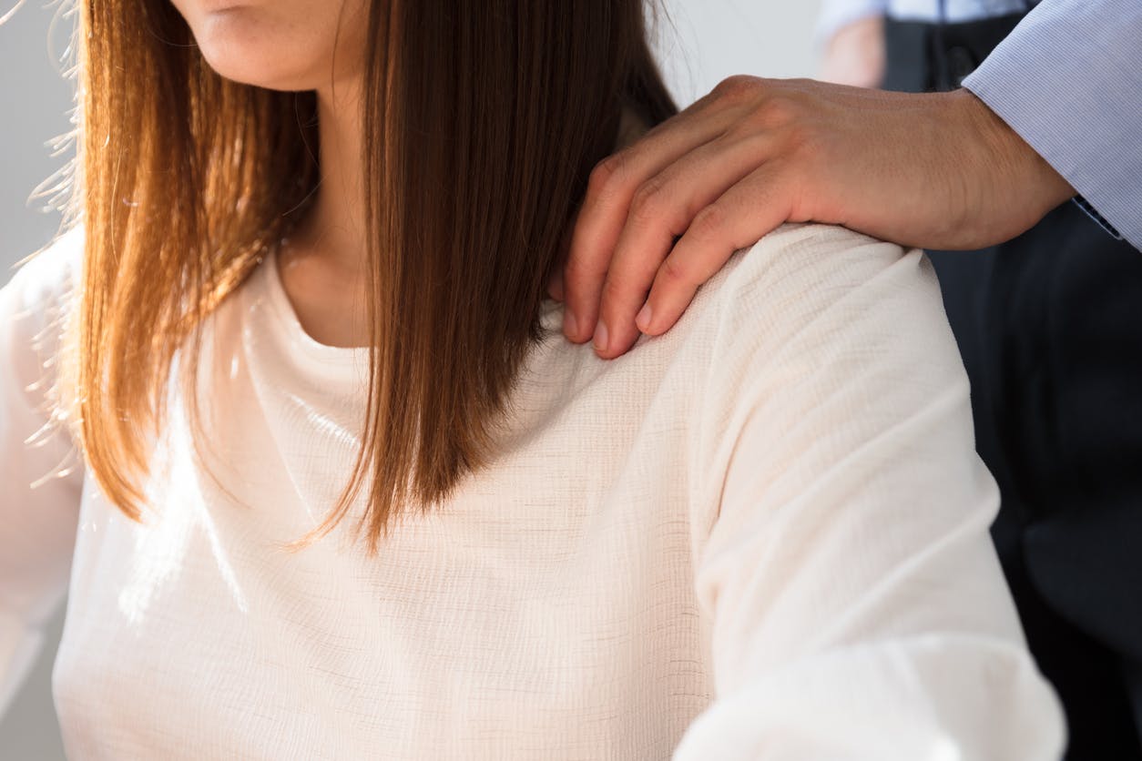 Man with his hand on a woman's shoulder