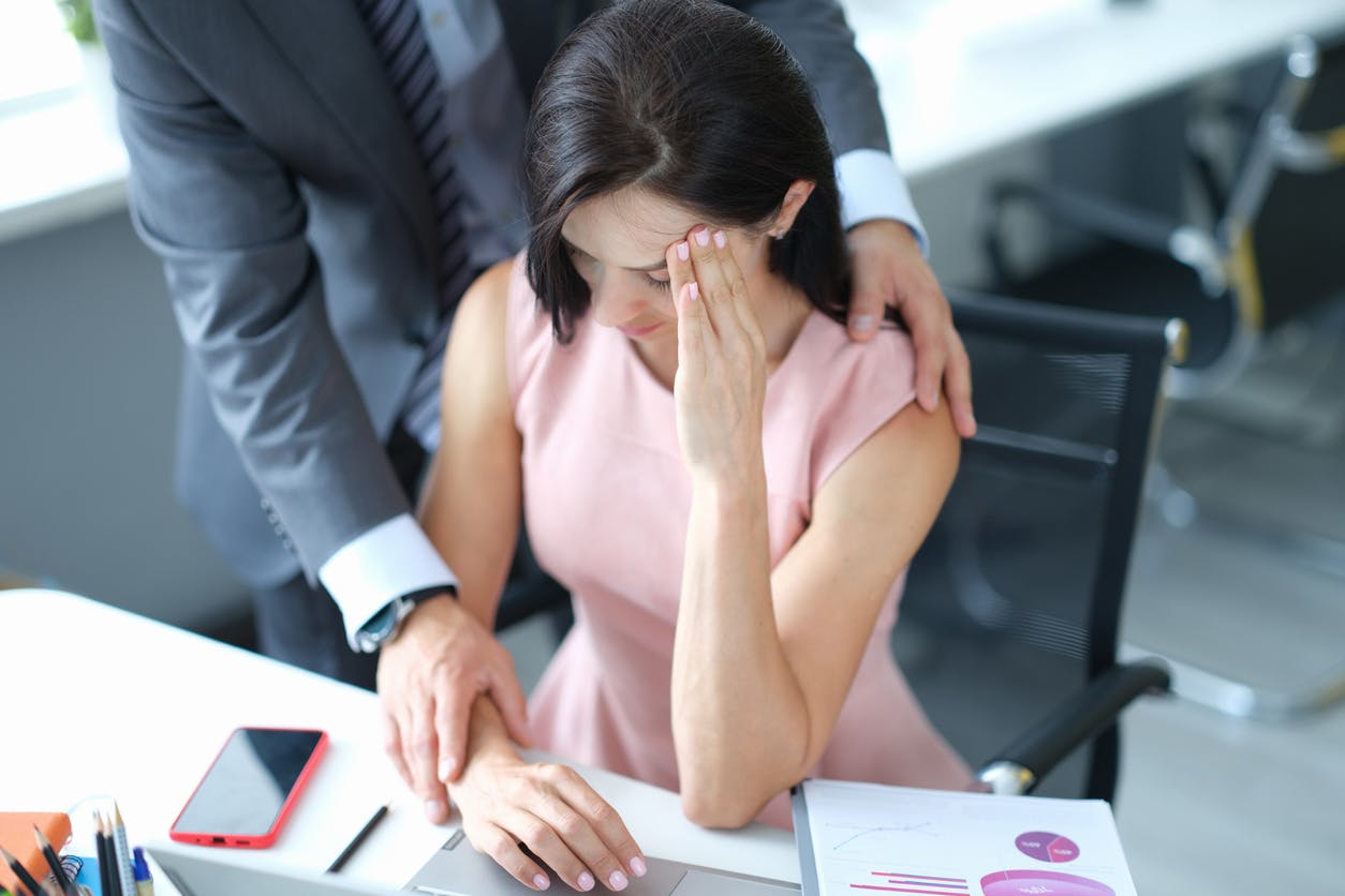 Woman being touched by another employee in the workplace.