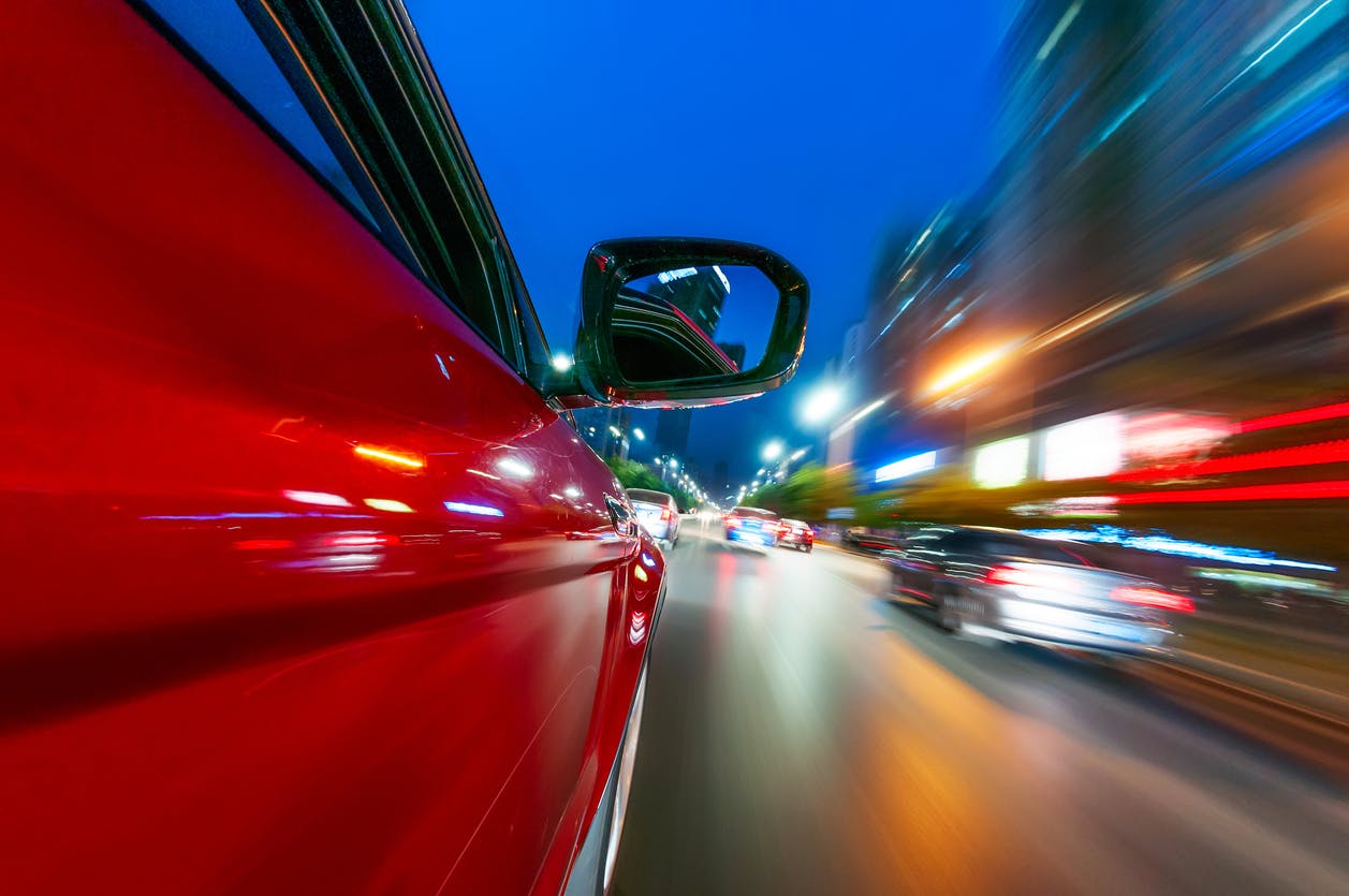 Side of a car in traffic with blurred motion and lights