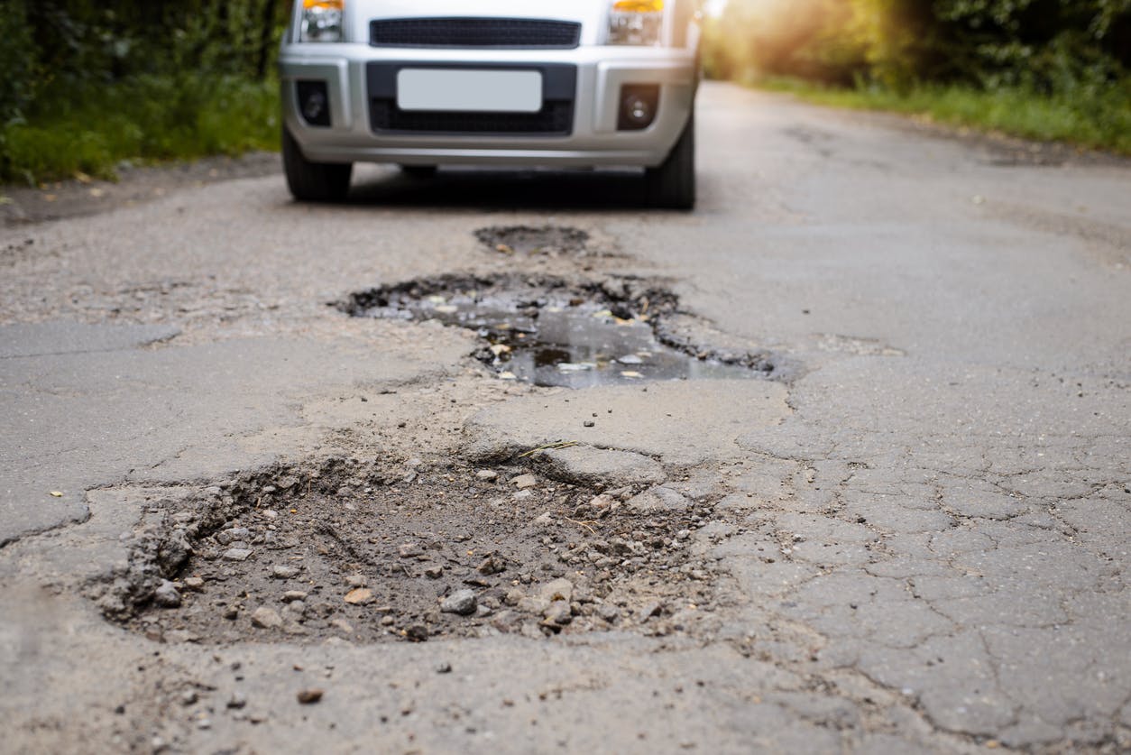 Car on a road with potholes