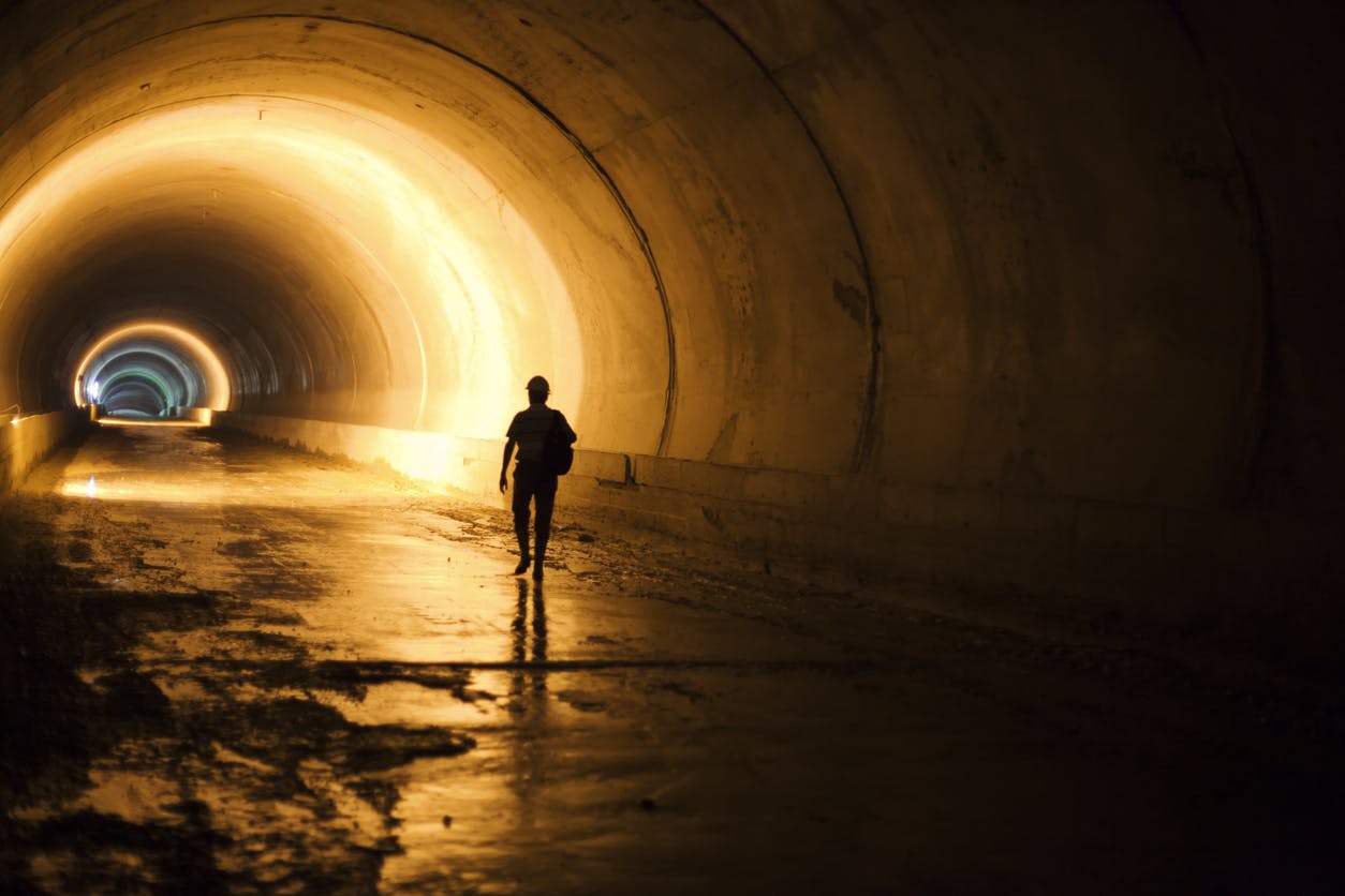 Worker walking down tunnel