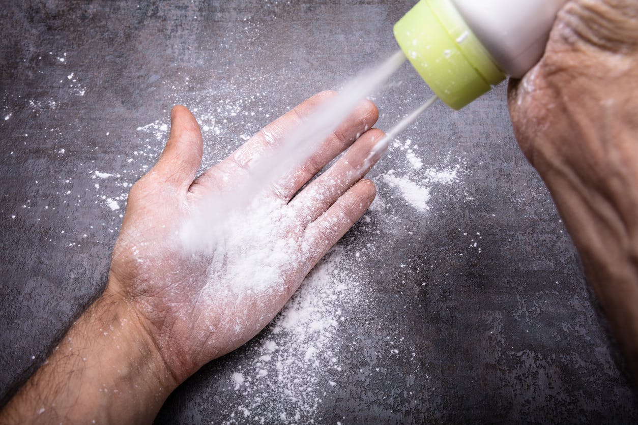 Person pouring talcom powder on their hands