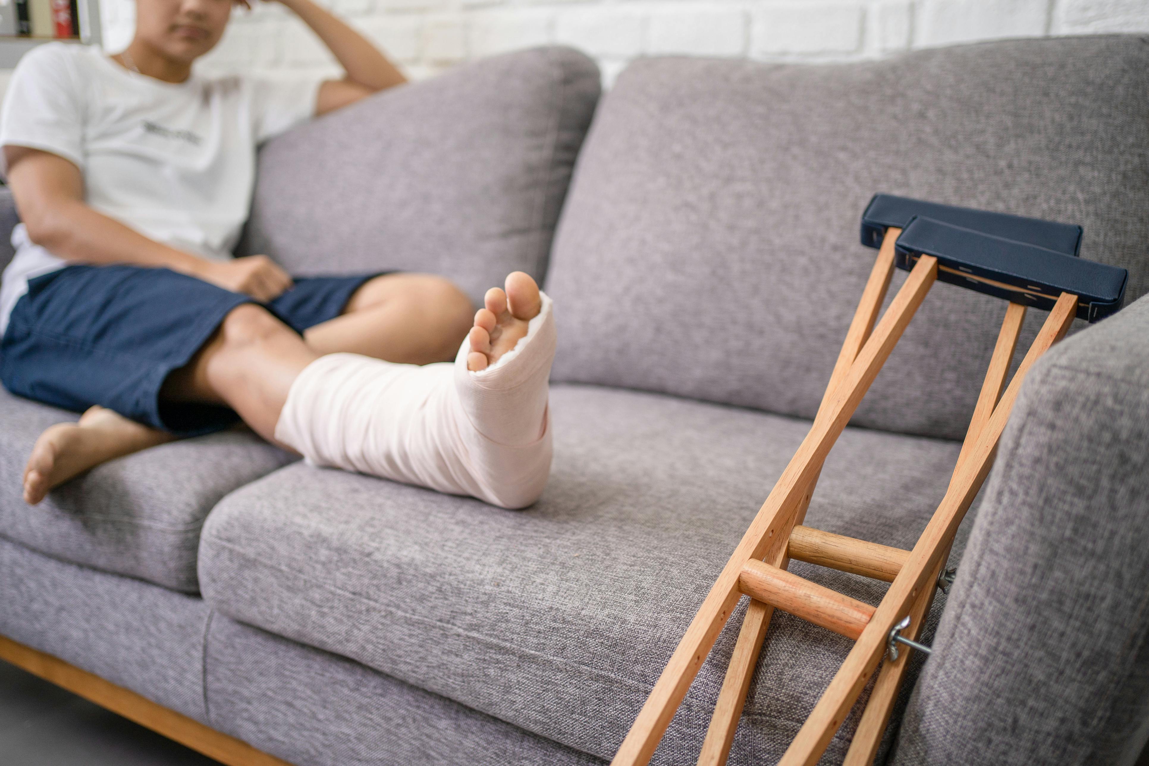 Woman sitting on the couch with a broken foot