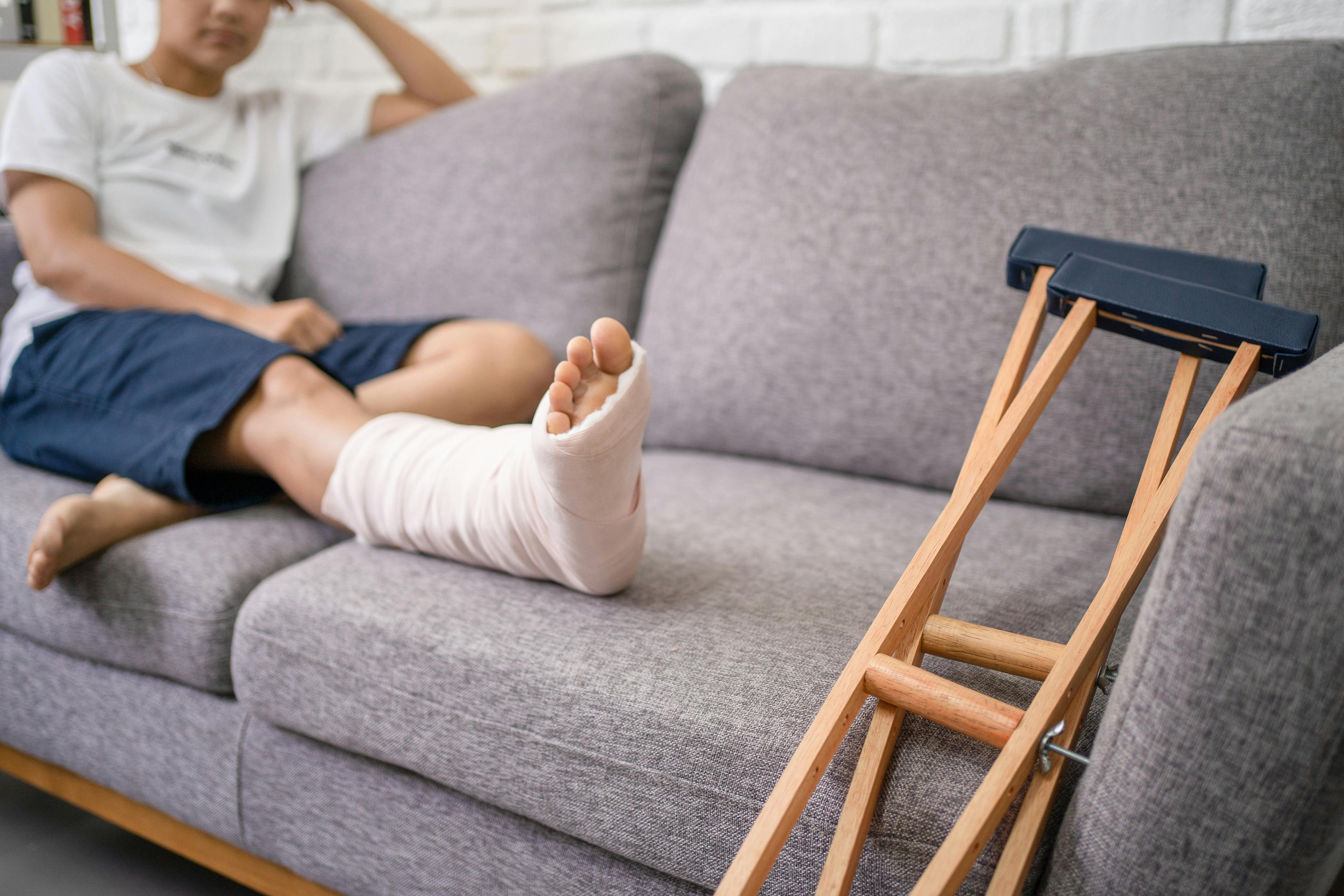 Woman sitting on the couch with a broken foot