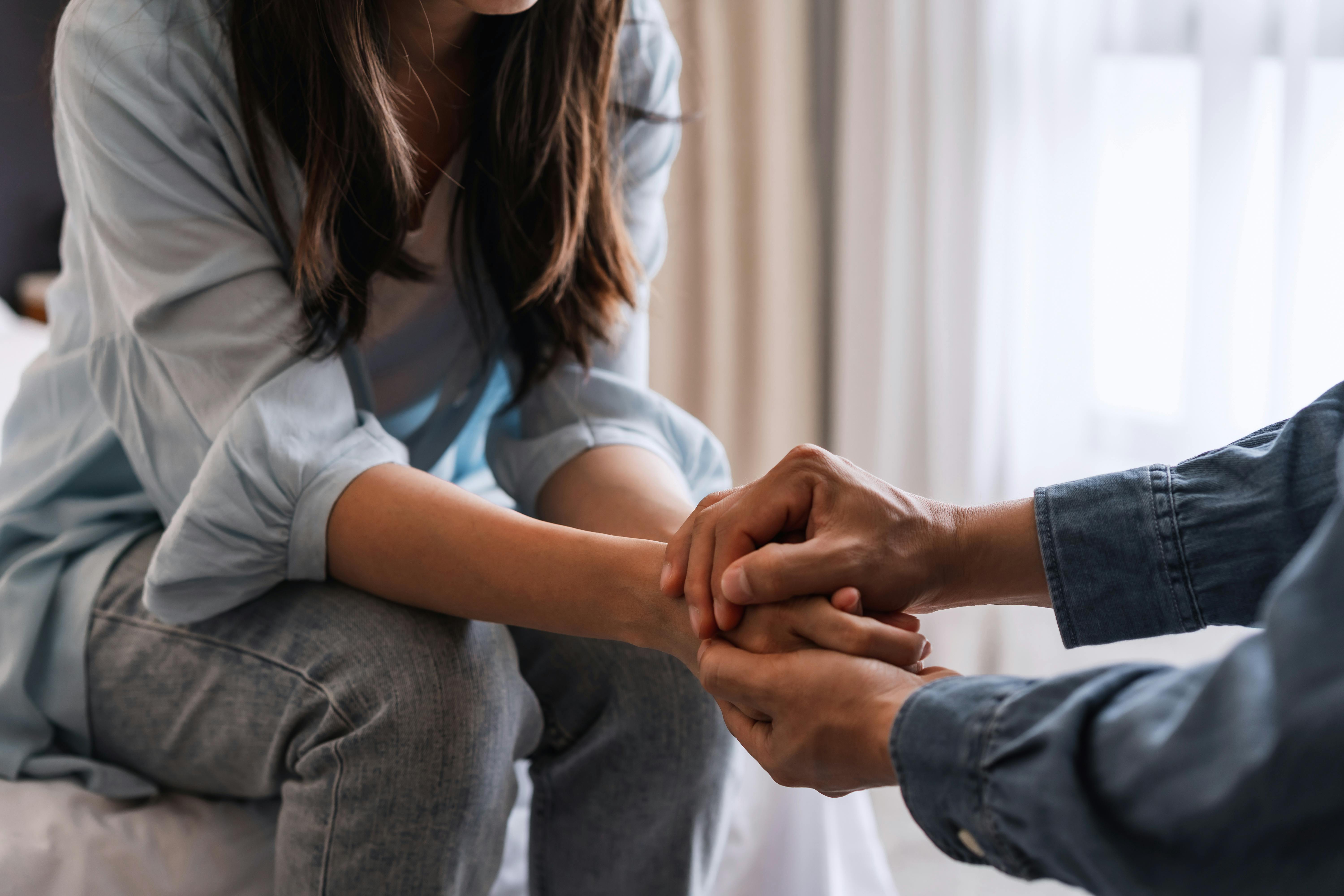 adult woman being comforted by another person