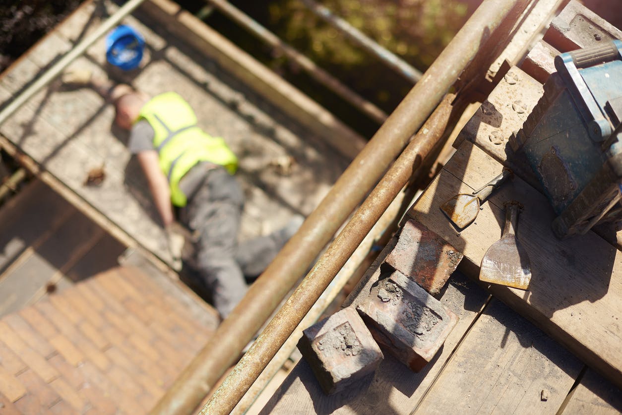 Injured construction worker lying face down on scaffolding