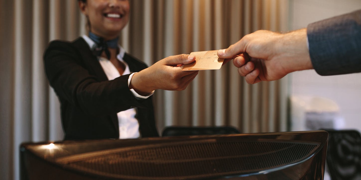 A  woman handing a man a credit card