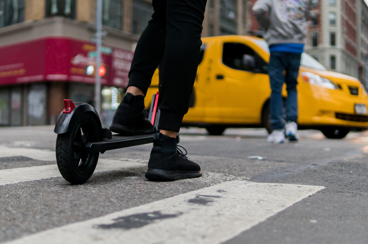 person in black riding a scooter