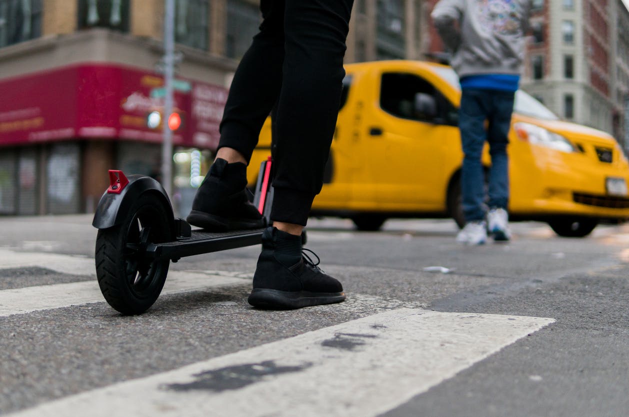 person in black riding a scooter