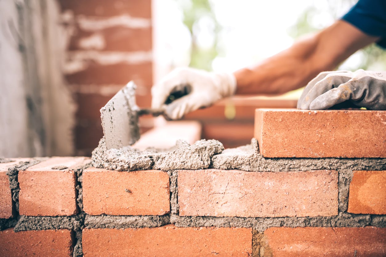 A person laying bricks