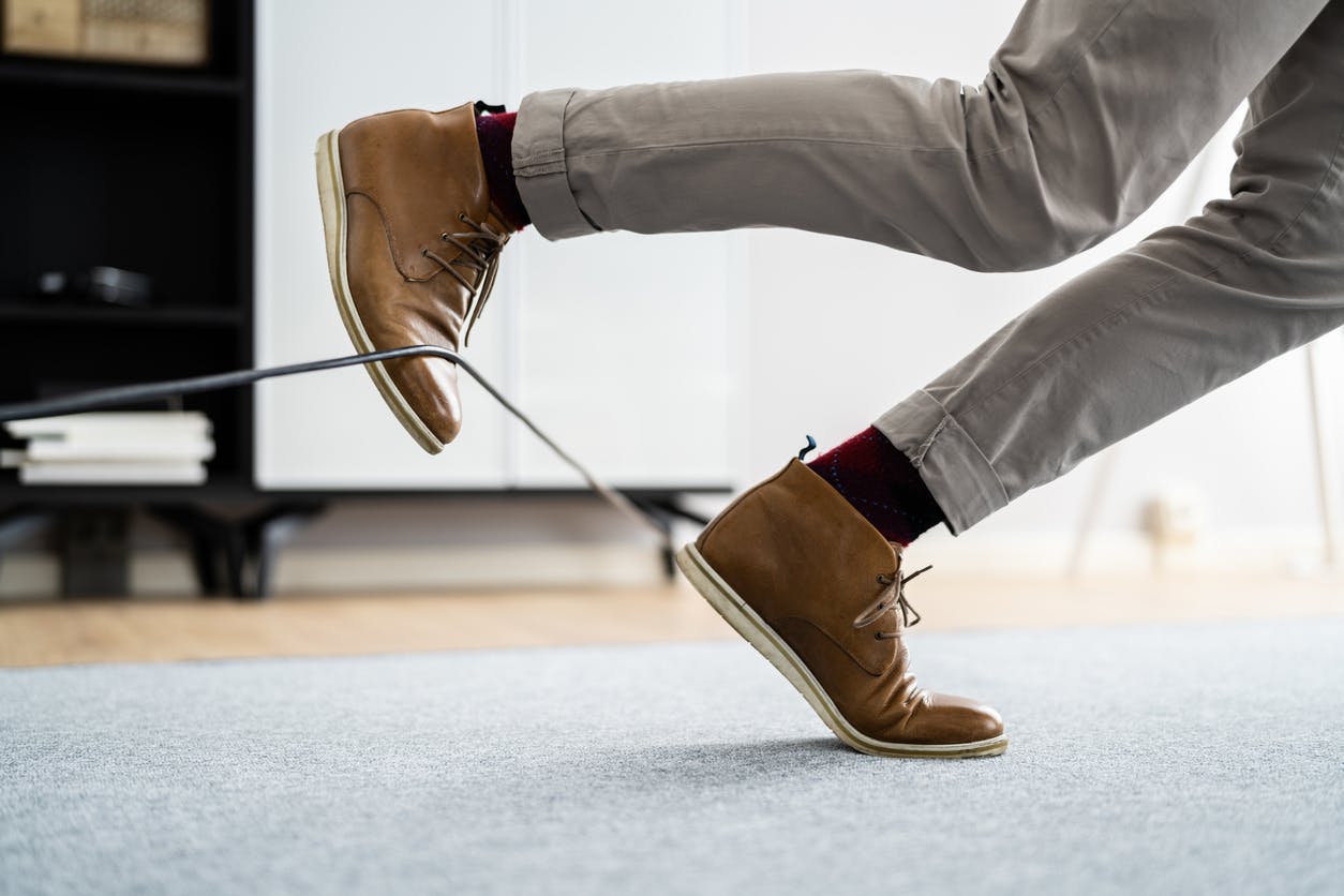 A man who is tripping over a wire
