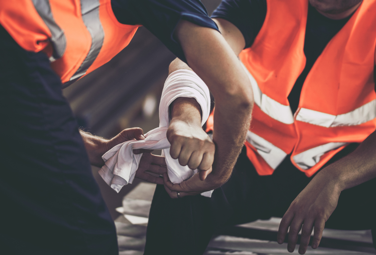 A construction worker getting his arm wrapped