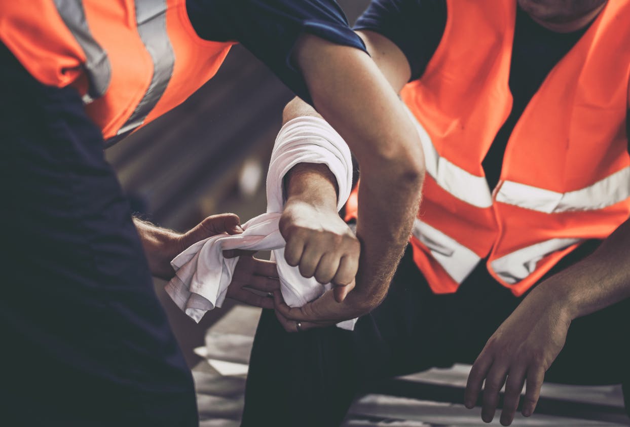 A construction worker getting his arm wrapped