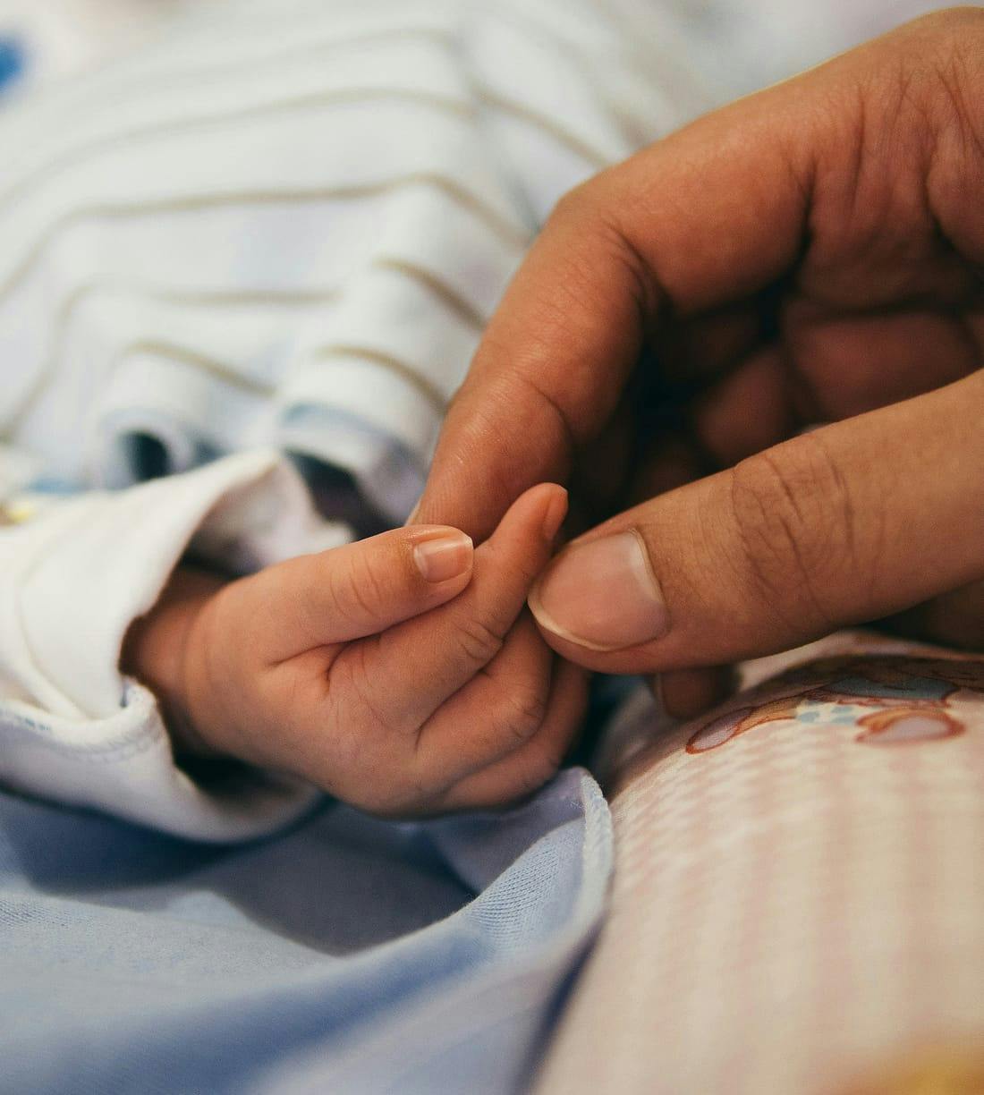 woman holding baby's hand