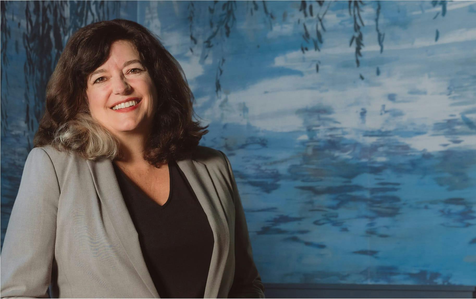 woman in gray suit smiling