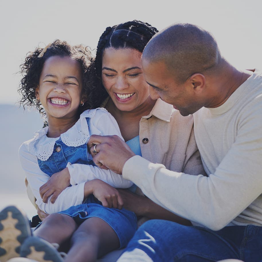 mother and father tickling their daughter