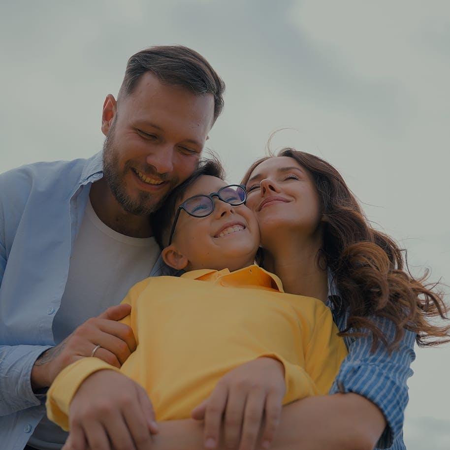 smiling couple embracing their son