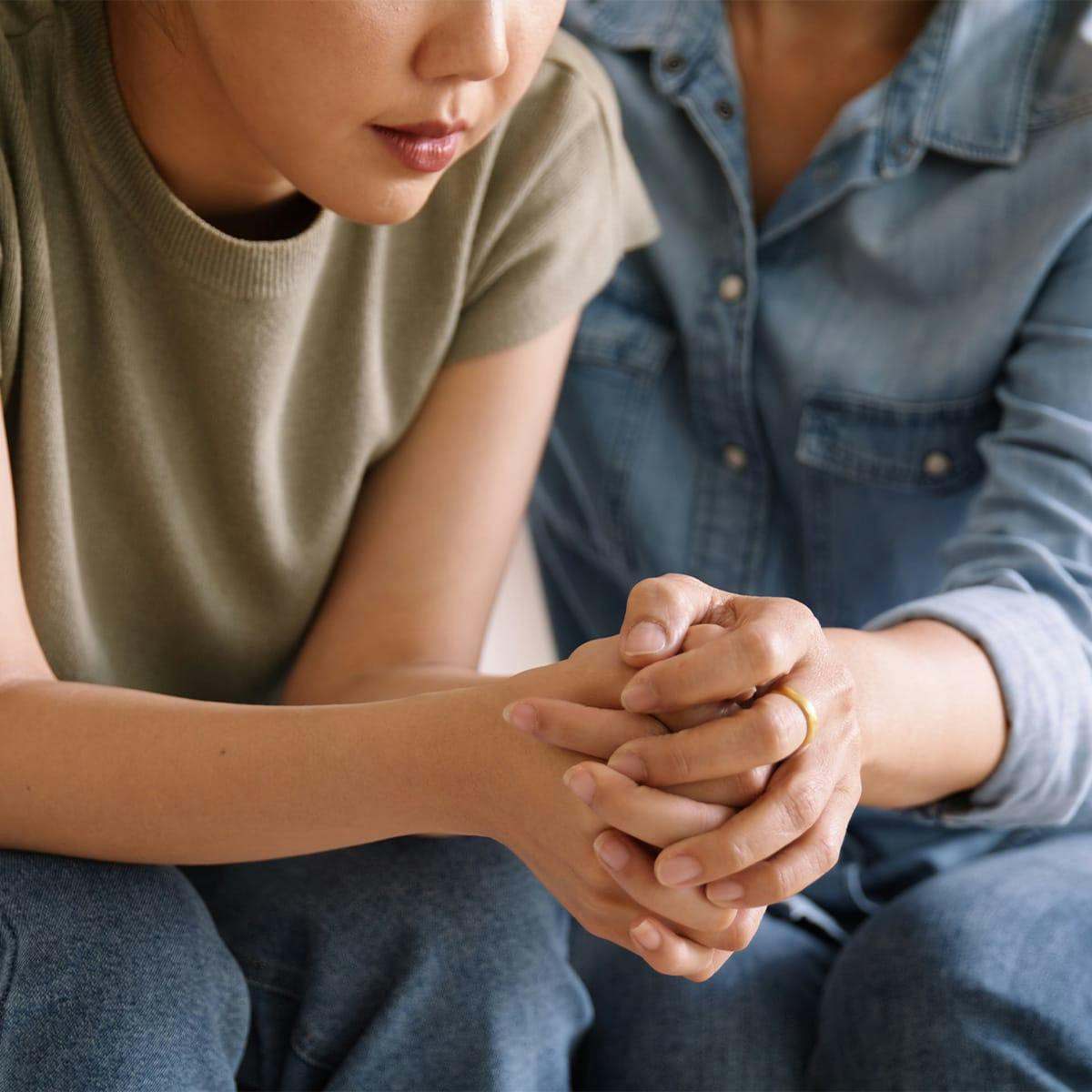 two woman holding hands
