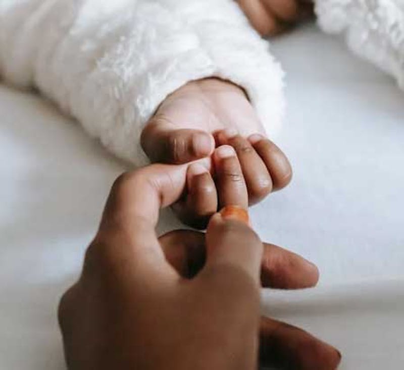 baby holding parents hand