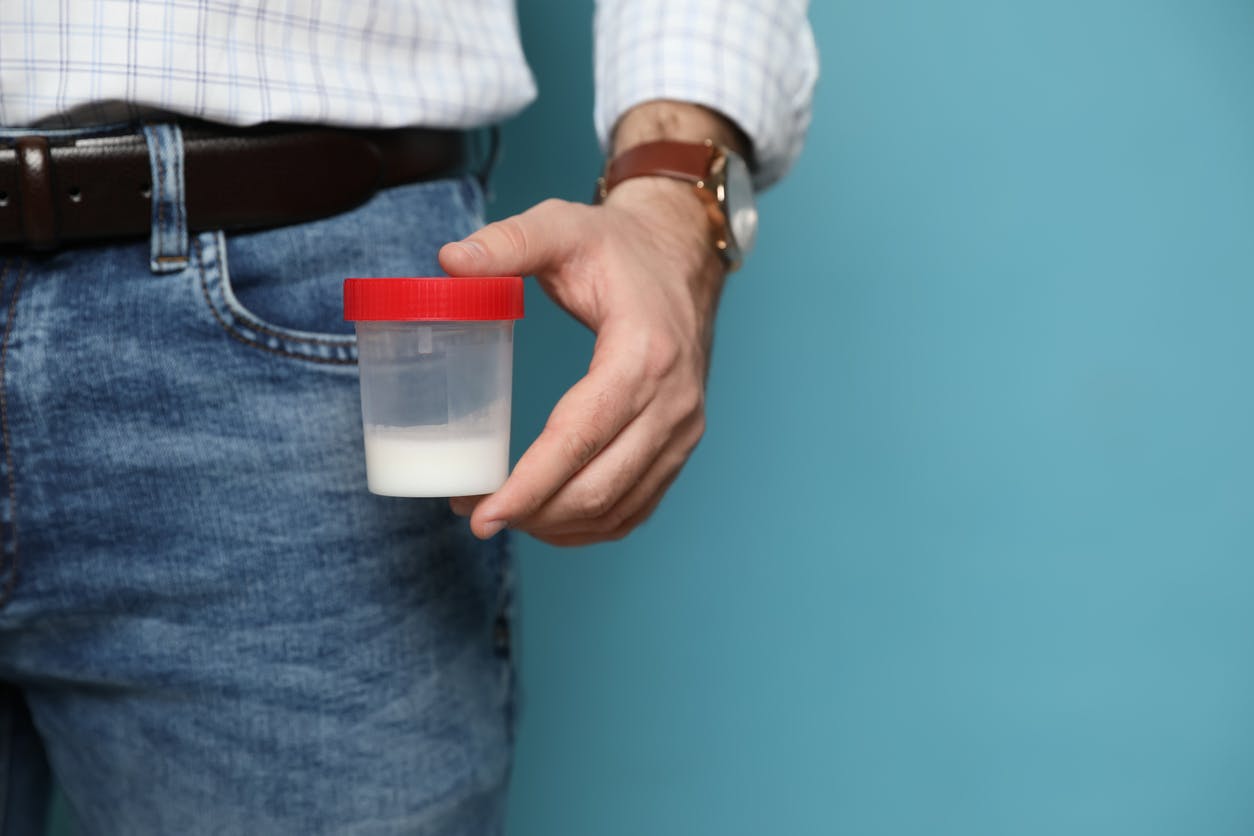 man holding a cup of a sample
