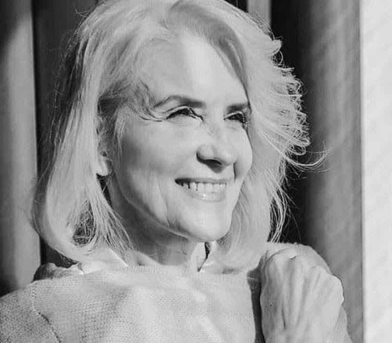 Beautiful older woman smiling, sun shining on her face