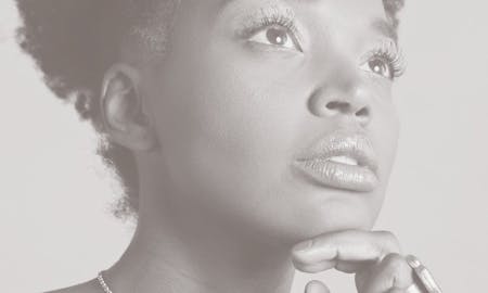 Woman looking to the side, touching her chin