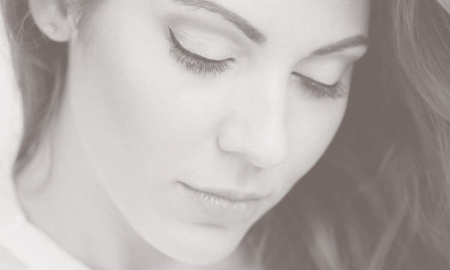 Beautiful woman's face, looking down, showcasing results of eyelid surgery in Nashville