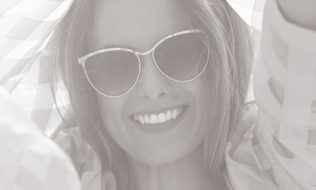 Smiling woman with sunglasses on.