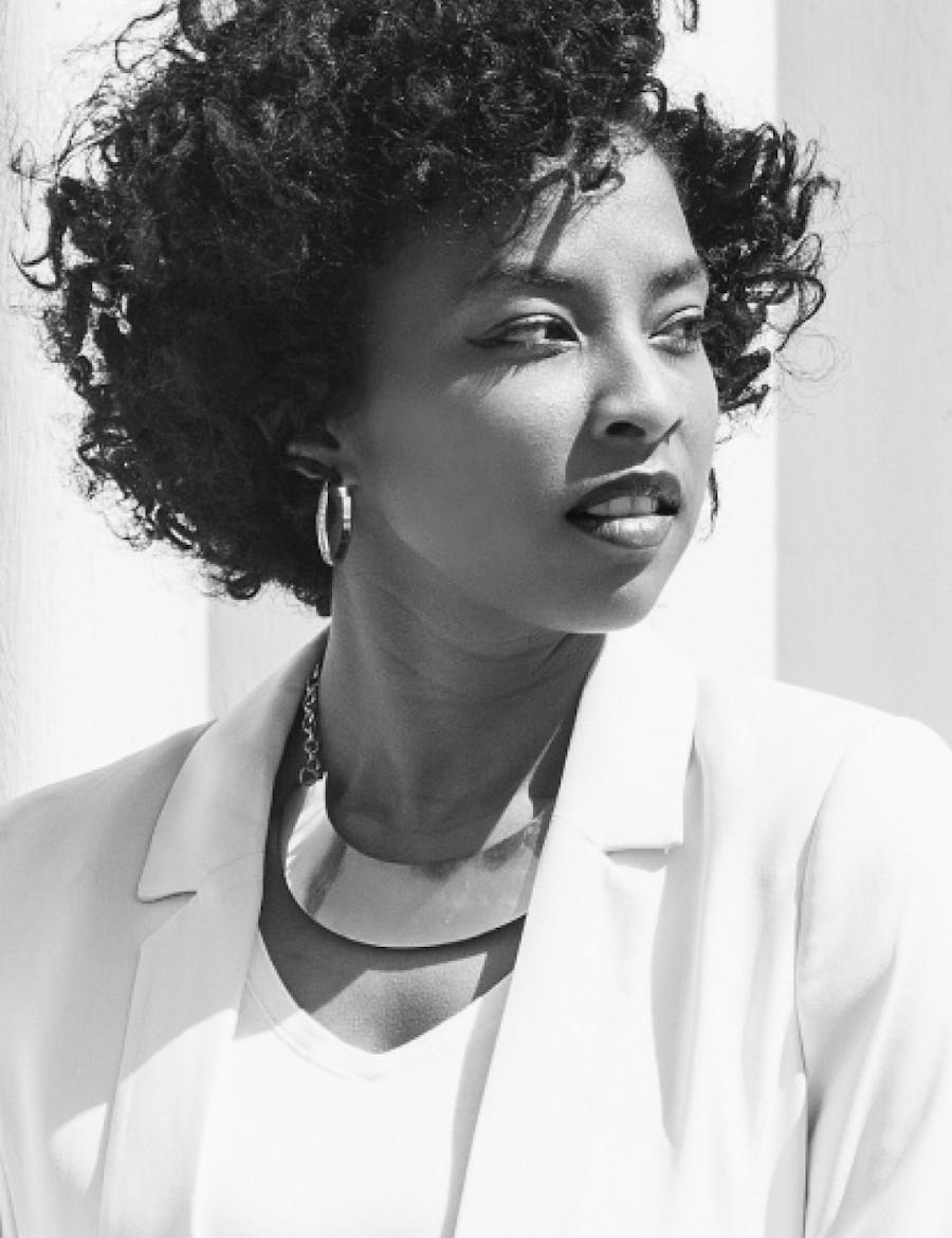 Woman in business attire looking off to the side.