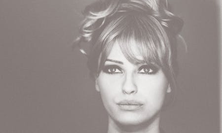 A beautiful woman with hair in an updo highlighting thin cheeks, the intended result of a facial fat transfer in Nashville