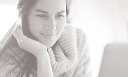 Woman resting her chin on her palm, smiling.