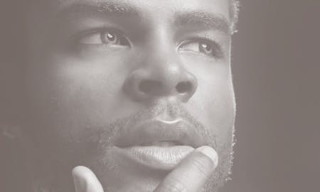 Dreamy man with a finger on his lips.