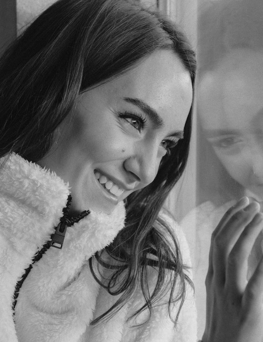 Women in a fur jacket looking out the window.