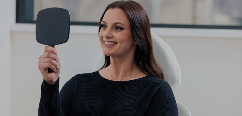 Woman smiling at her cosmetic treatment results.
