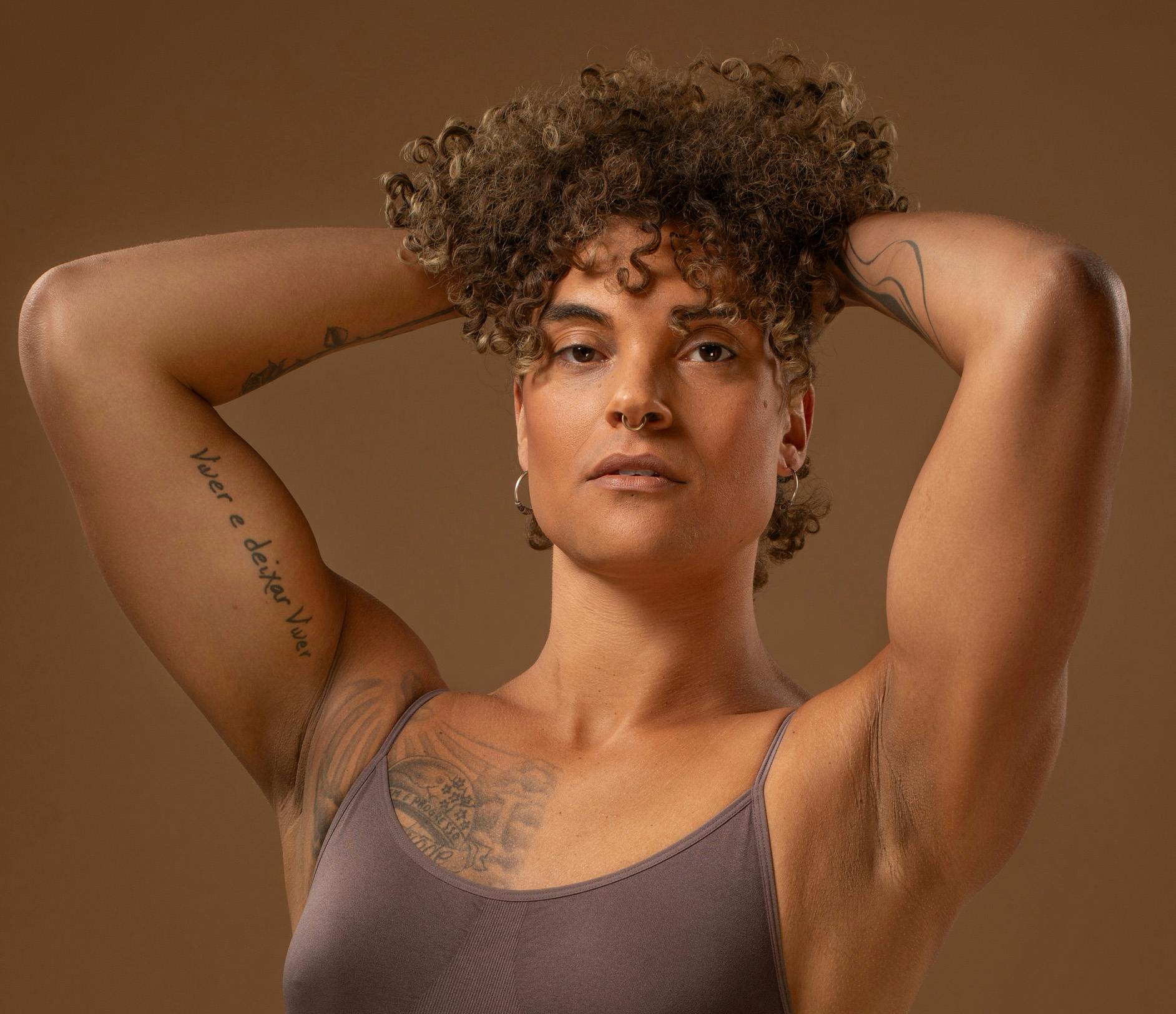 feminine person with curly hair and tattoos