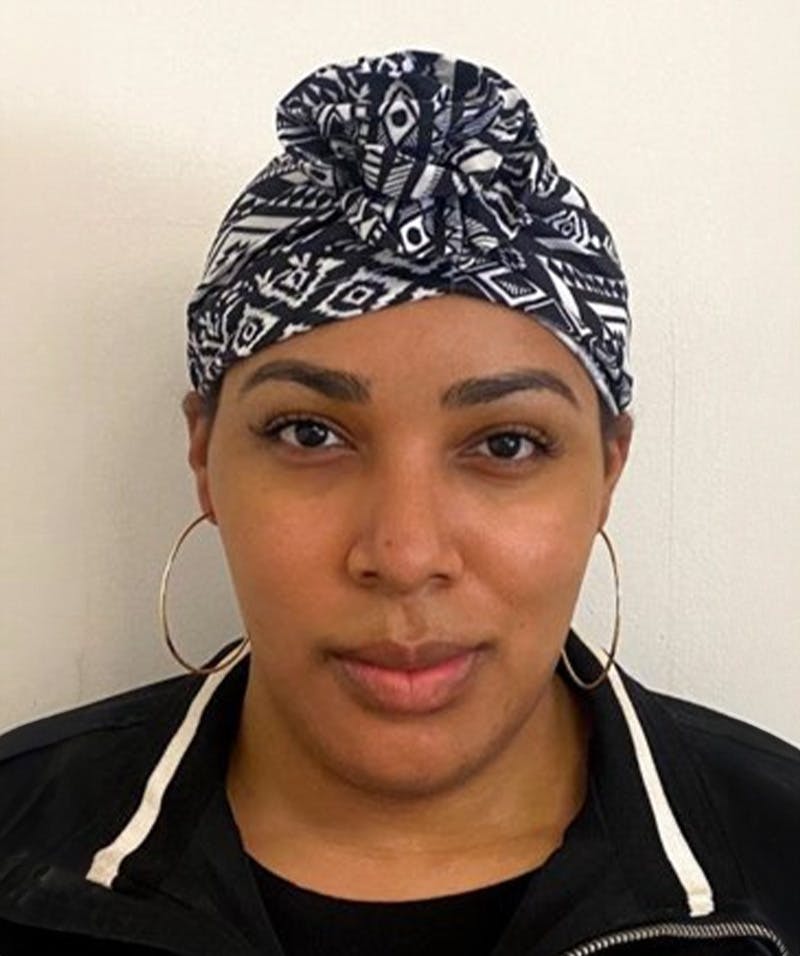 person wearing a head scar and gold hoop earrings