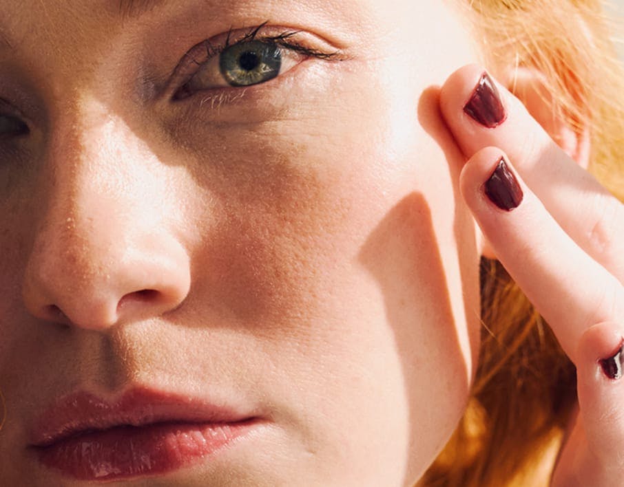 woman touching her cheek