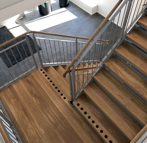 Gerade Treppe drinnen mit Holzstufen und Handlauf- und Kontrastmarkierung