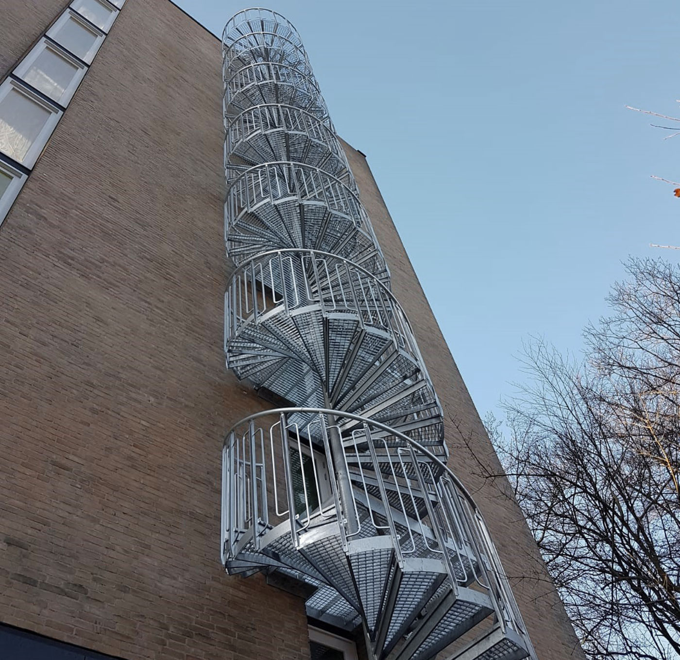 Spindeltreppe im Freien mit Gitterroststufen und kindersicherem Geländer
