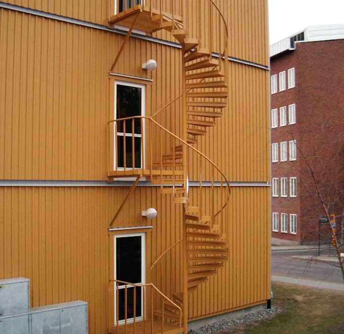 Powder coated spiral staircase outdoors with industrial railing