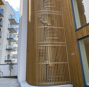 Feuerverzinkte Spindeltreppe mit bodenverbundenem Käfig aus Holz
