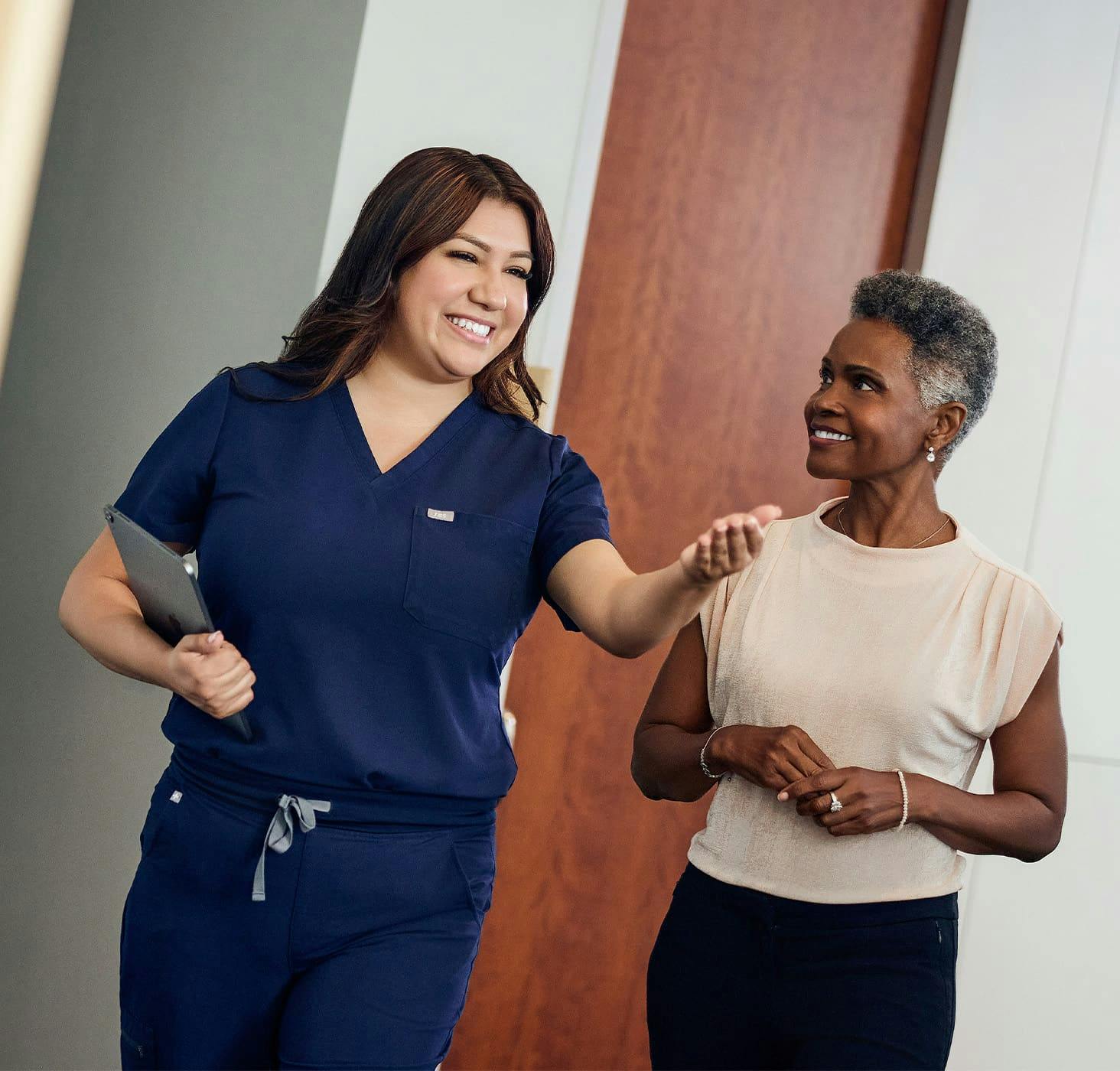 female patient walking with staff member