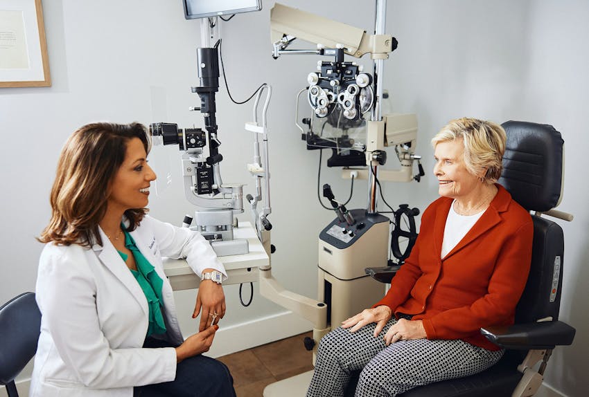 staff looking at patient's eye with small magnifying glass