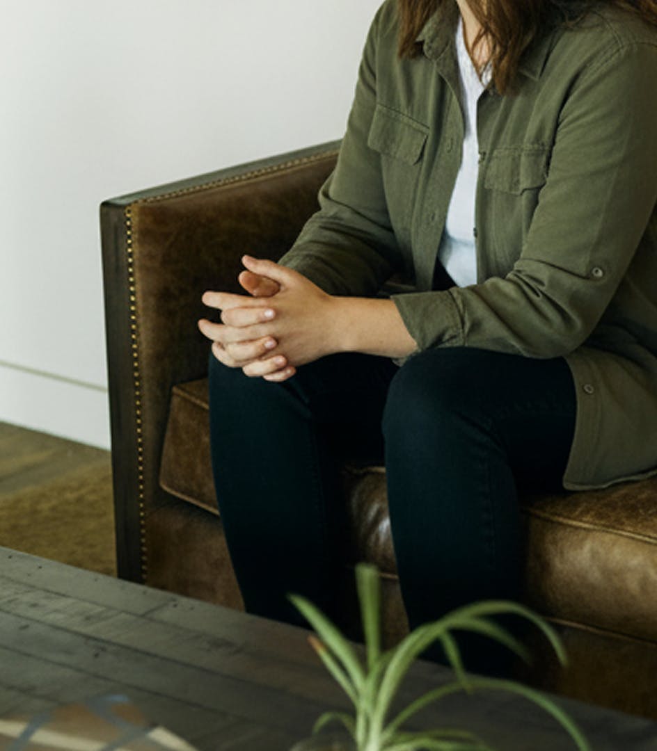 woman sitting down with clasped hands