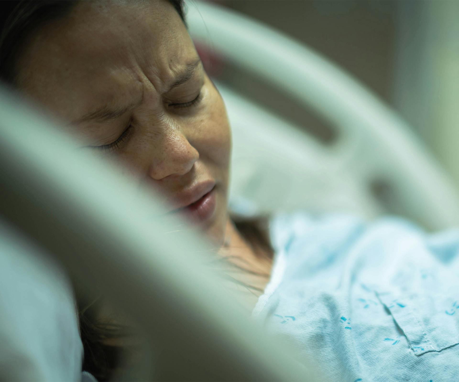 woman in hospital bed in pain