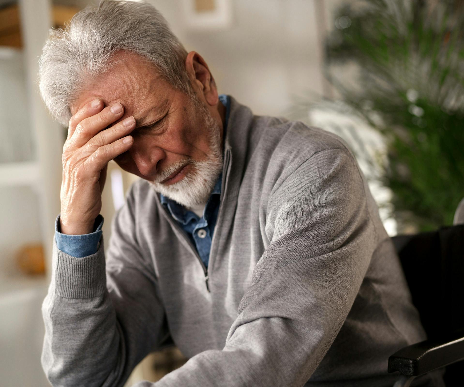 elderly man with head in hands