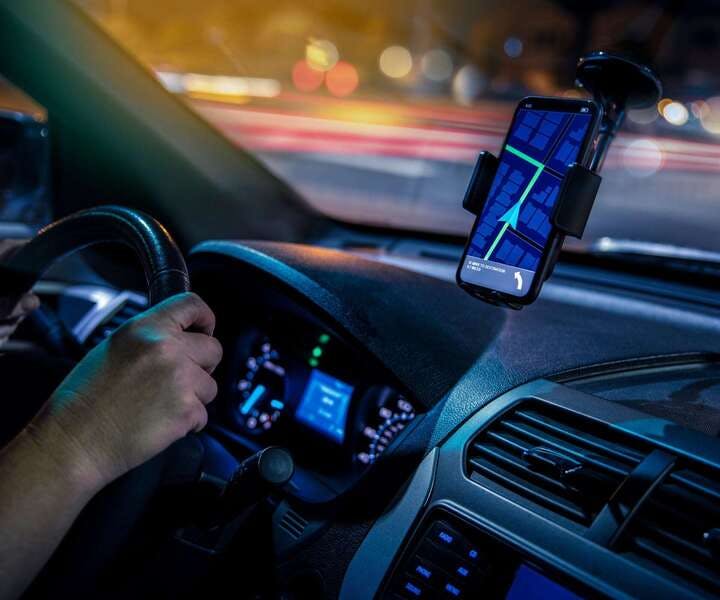 uber driver in car using directions on phone