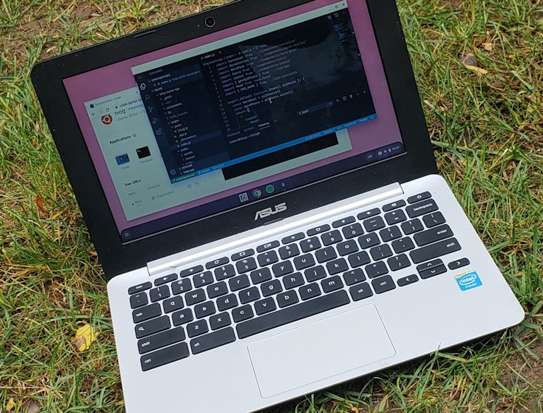 Photograph of a laptop in the grass. It's being used for development