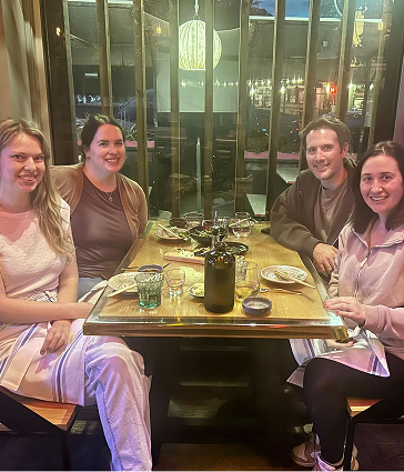 4 people smiling seated at a restaurant booth table